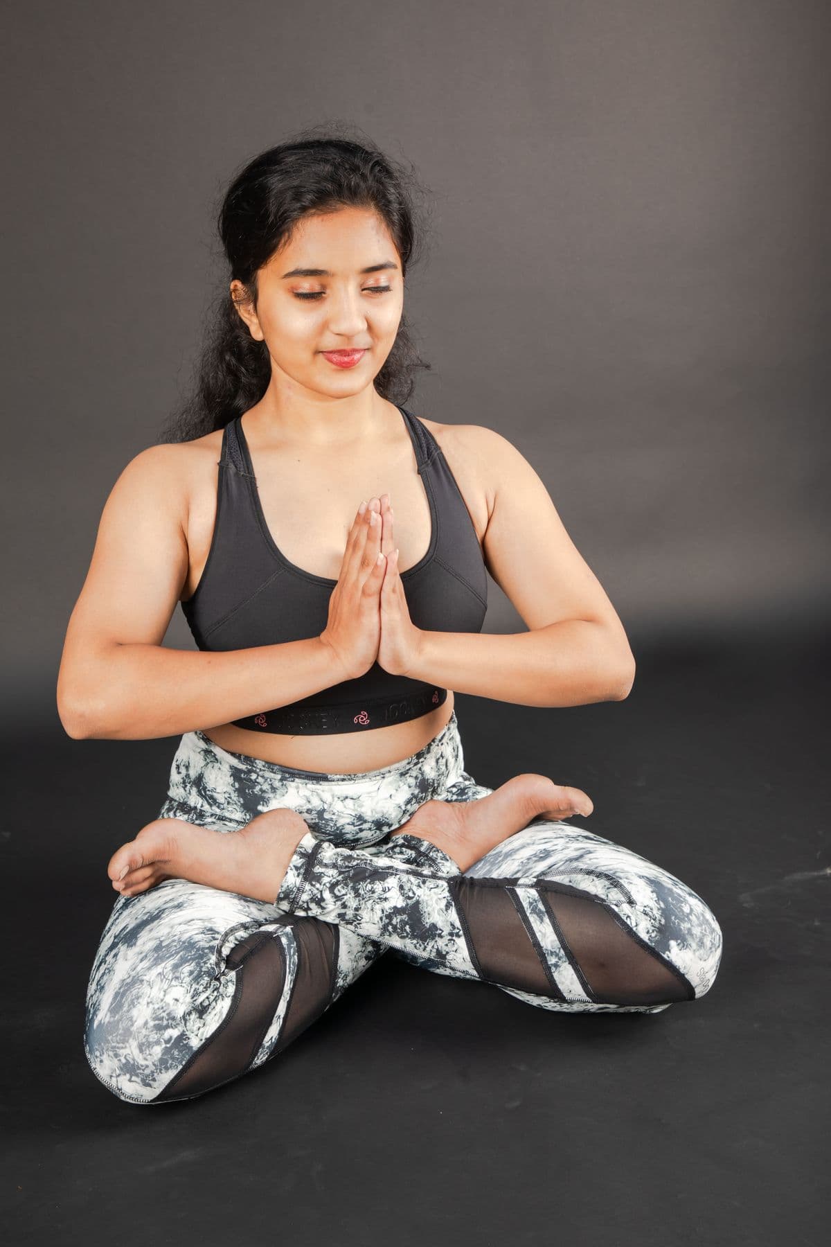 Woman smiling in a seated namaste